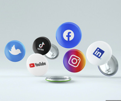 verschiedene fliegende Buttons mit aufgedruckten Social Media-Logos vor grauem Hintergrund