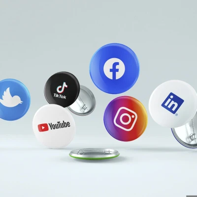 verschiedene fliegende Buttons mit aufgedruckten Social Media-Logos vor grauem Hintergrund