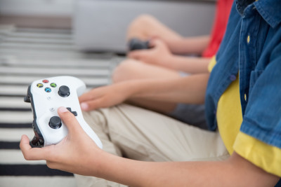 Zwei Kinder spielen Videospiele mit Controllern