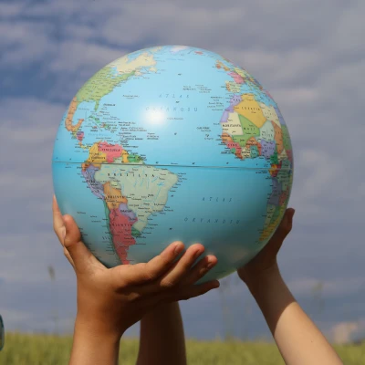 Kinderhände halten einen Globus in die Luft
