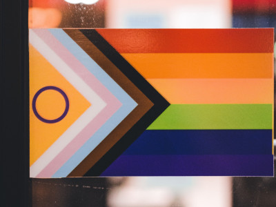 Pride-Flagge, die in Innenräumen präsentiert wird und LGBTQ+-Inklusivität und Vielfalt symbolisiert.