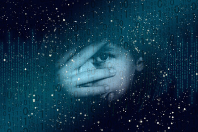 Kind hält sich Hand vor das Gesicht und guckt mit einem Auge zwischen den Fingern hervor - rundherum ein Hintergrund mit Nullen und Einsen