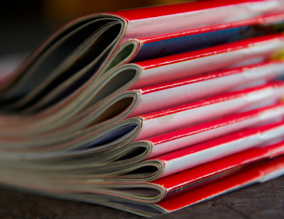 Ein Stapel von Zeitschriften mit rotem Cover. Keine erkennbaren Details.