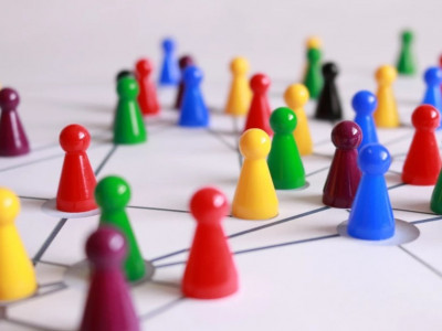 Viele bunte Spielkegel befinden sich auf einer weißen Unterlage und sind mit gezeichneten Strichen miteinander verbunden.