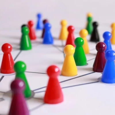 Viele bunte Spielkegel befinden sich auf einer weißen Unterlage und sind mit gezeichneten Strichen miteinander verbunden.
