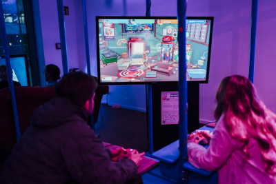 Mann und Frau spielen mit Controller gemeinsam ein Videospiel