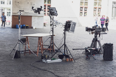verschiedene technische Geräte, wie Kamera, Stative, Mikrofone an einem Filmset.