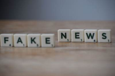 aufgestellte Scrabble-Steine auf einem Tisch mit den Worten Fake und news